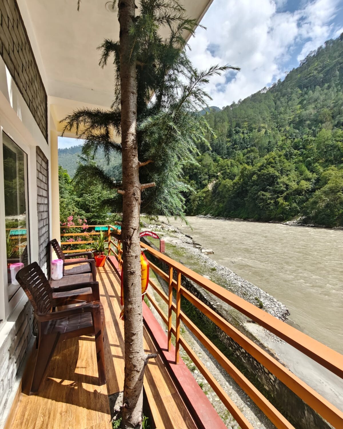 A private balcony with seating overlooking the Bhagirathi River at Uttarkashi
