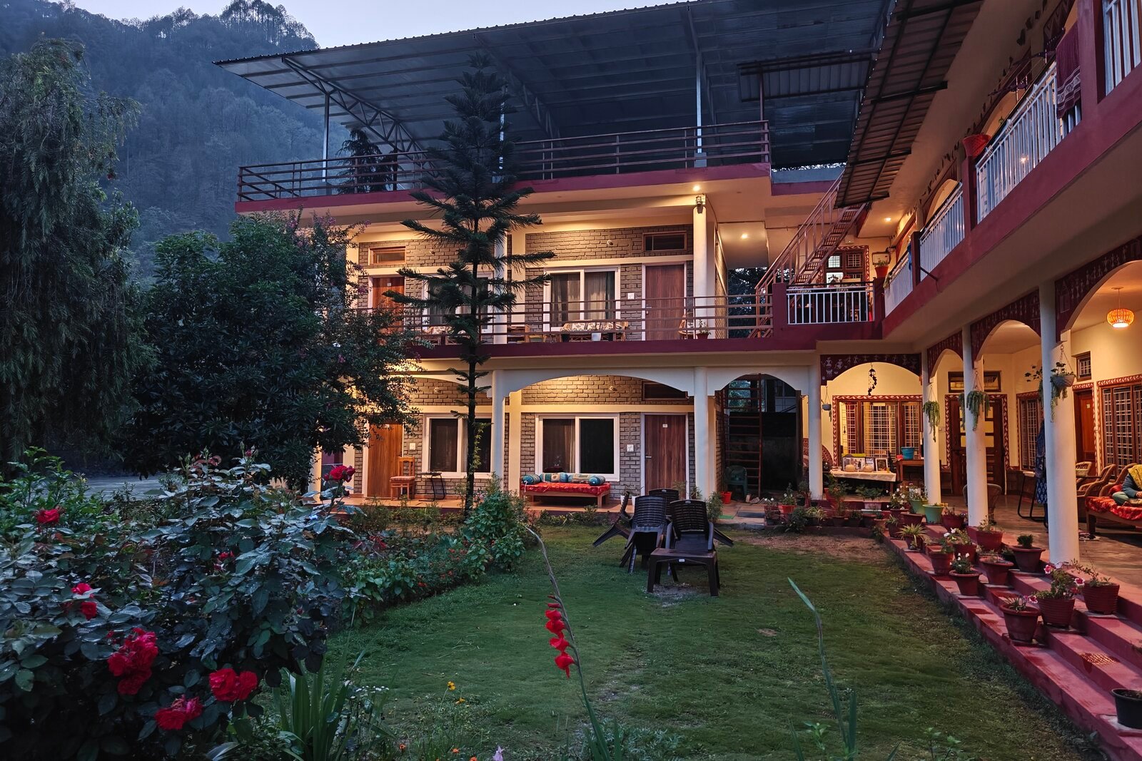 The Uttarkashi residential campus at dusk, lights on across the courtyard