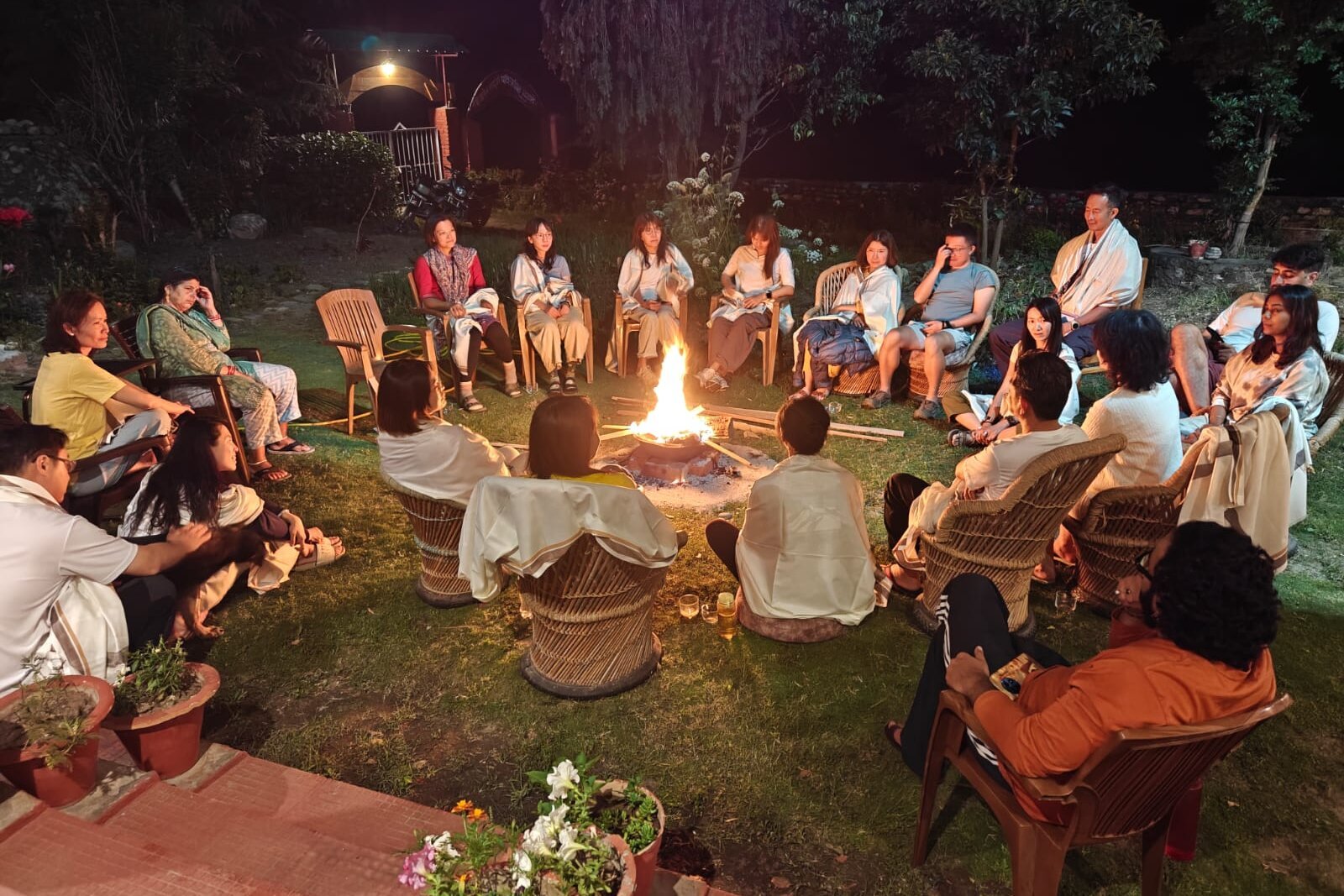 Students and teachers gathered around an evening fire at the Uttarkashi campus