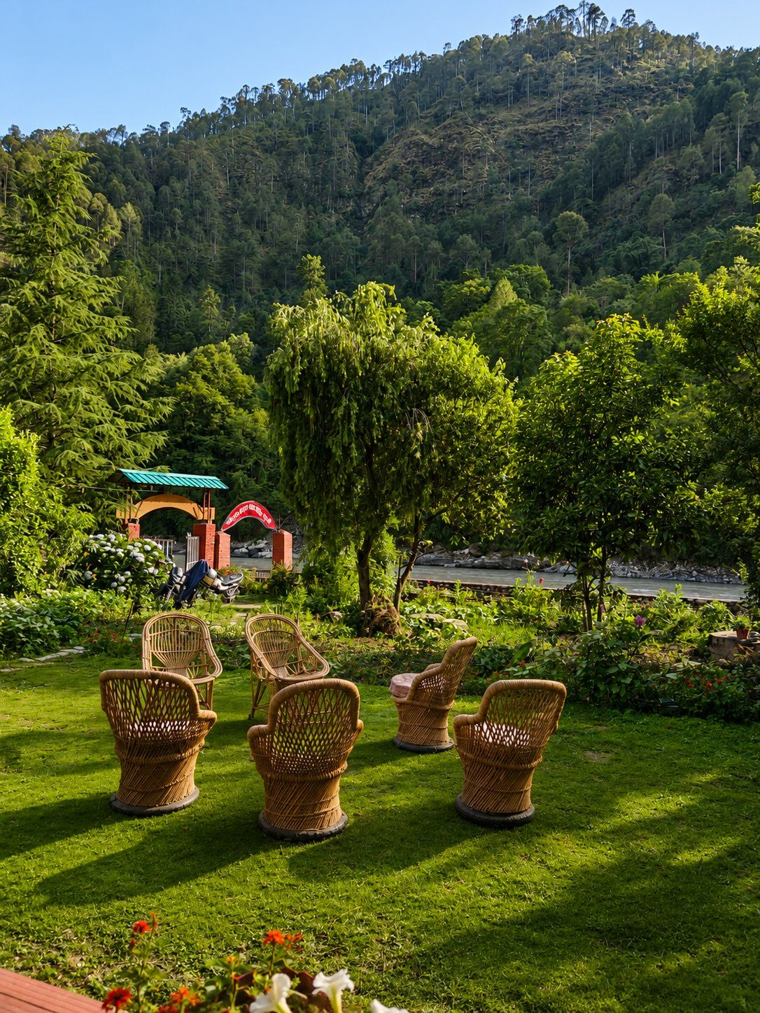 Garden seating at our Uttarkashi campus, with forested hills and the river beyond