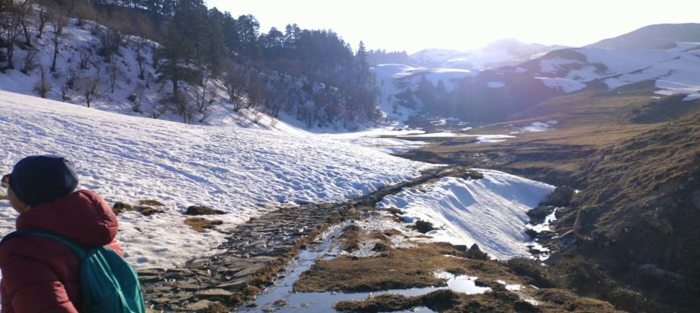 A snow-covered Himalayan ridge and stream near Uttarkashi in winter