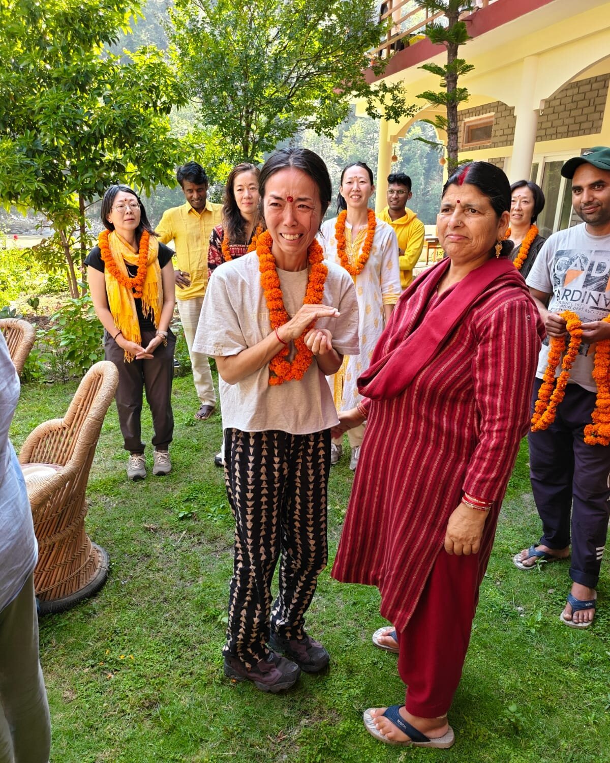 Students and staff being welcomed with marigold garlands in the garden at Uttarkashi
